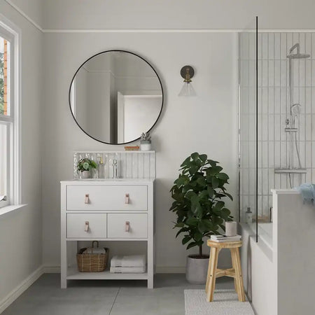 Bathroom interior painted with dulux easycare bathroom pure brilliant white. with a round mirror, white cabinet, plant, and stool.