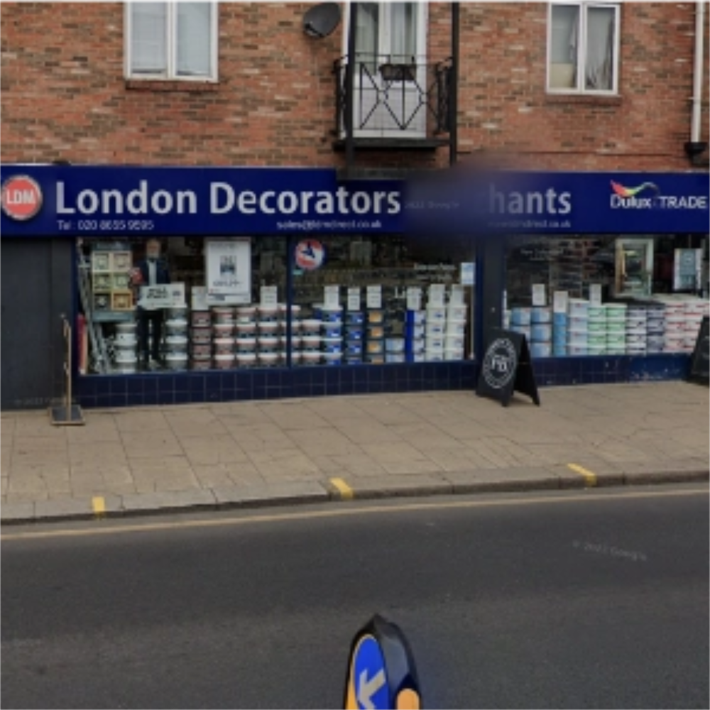 Storefront of London Decorators Merchants Wandsworth with a blue sign on a brick building.