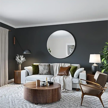 Ultra-matt ceiling finish achieved with Tikkurila Anti-Reflex 2 White showing no flashing or roller marks in a Modern living room with a round mirror, sofa, coffee table, and chair.